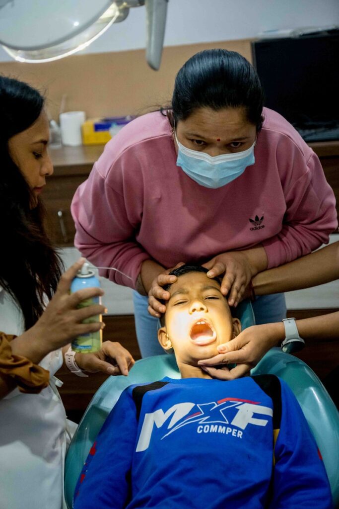 a woman getting her teeth checked by a dentist