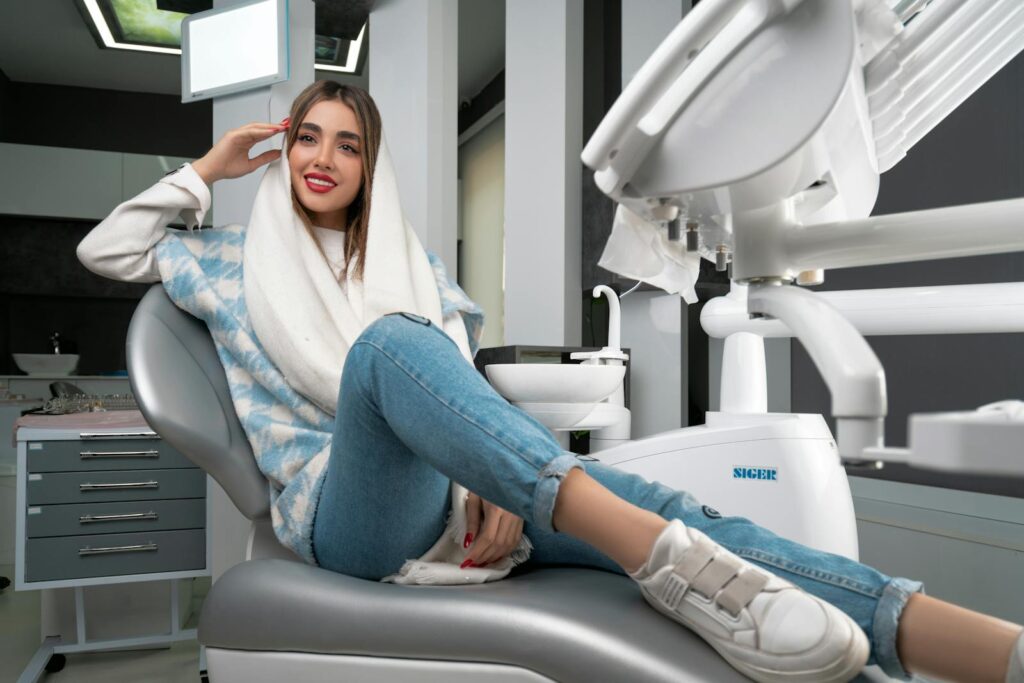 A stylish woman in casual wear smiling confidently in a modern dental clinic.